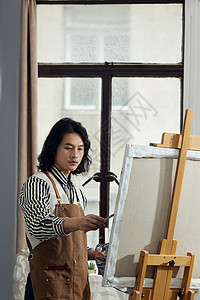 油画工作室里创作的青年男画家图片