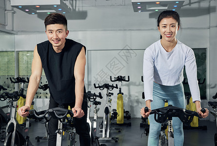 动感单车练习的健身男女图片