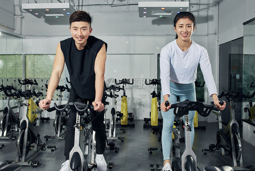 动感单车练习的健身男女图片
