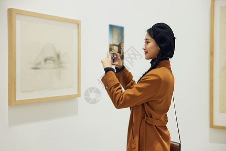 博物馆看展拍照的青年女性图片
