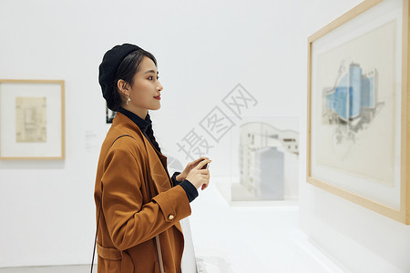 文艺女青年看展拿手机拍照图片