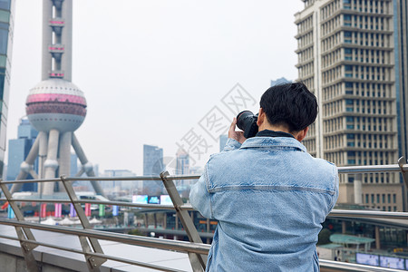 轻年男性男摄影师拍摄城市风光背景