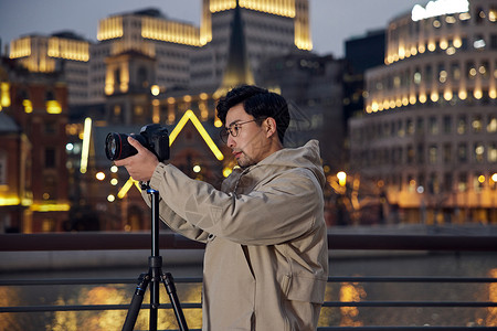 工作照片男摄影师拍摄城市夜景背景