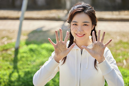 女性微笑展示沾满泥土的双手高清图片