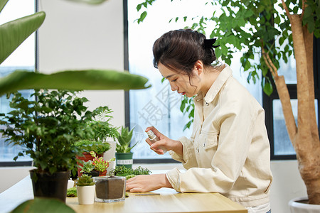 使用喷壶对植物喷水的女性高清图片