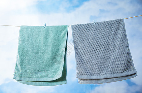 室外蓝天下晾晒着的毛巾背景图片