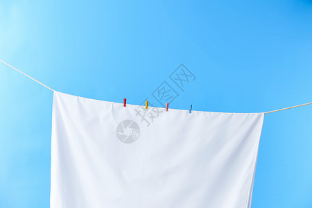 晾衣绳上晾晒着的白毛巾高清图片