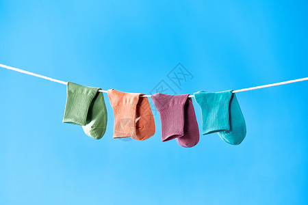 晾衣绳上晾晒着的彩色袜子高清图片