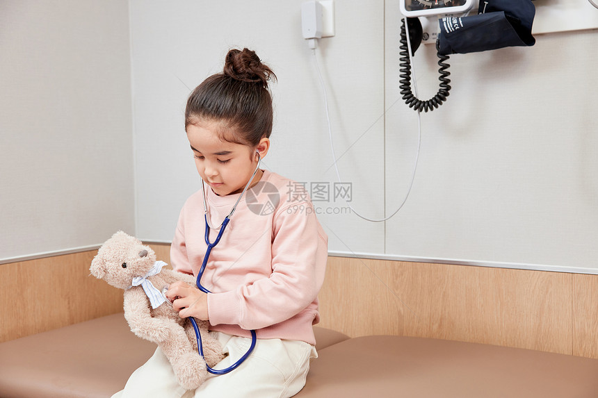 小女孩给小熊使用听诊器图片