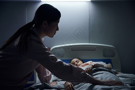 医院里照顾生病女儿的母亲背景图片
