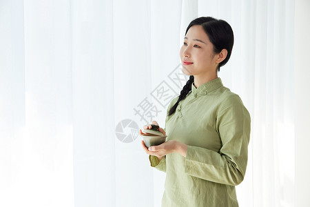 素雅女性手拿茶杯背景图片