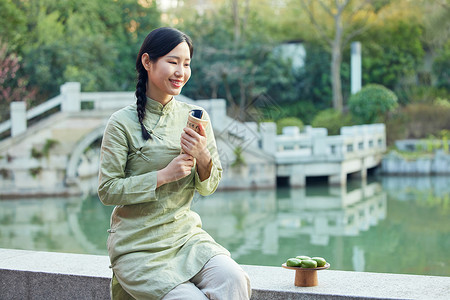 吃青团的女孩室外看书吃青团的青年女性背景