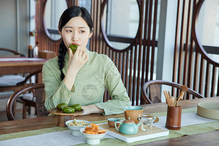 吃青团的女孩在茶馆吃青团品茶的气质女性背景