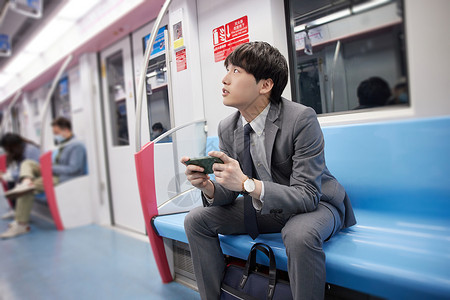 地铁上使用手机的商务男性图片