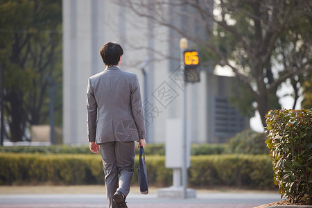 走在人行道上的职场男性背影图片