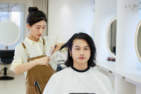 女性理发师给顾客剪头发形象图片