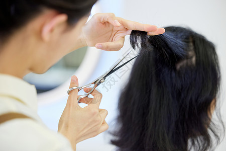 兔年发型女女理发师给顾客剪头发手部特写背景