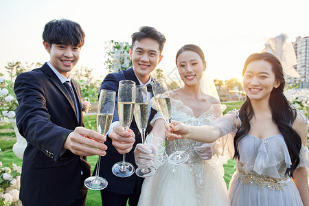 举行户外婚礼的新人开香槟庆祝新婚背景图片