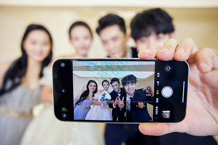 新郎新娘与伴郎伴娘拿手机自拍形象背景图片