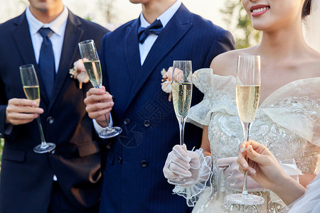 举行户外婚礼的新人举杯庆祝特写图片