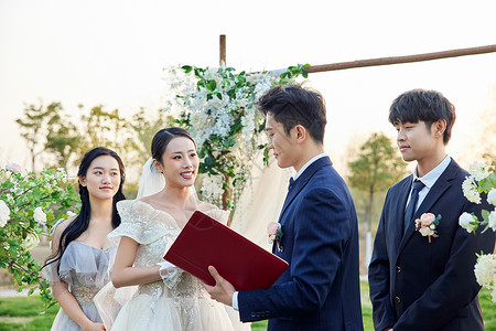 新婚夫妻在户外婚礼上读宣誓词高清图片