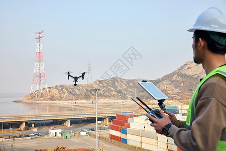 航拍摄影师使用无人机勘探港口高清图片