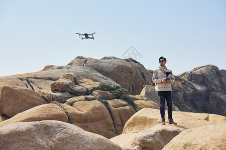 航拍摄影师山顶使用无人机拍摄风景图片