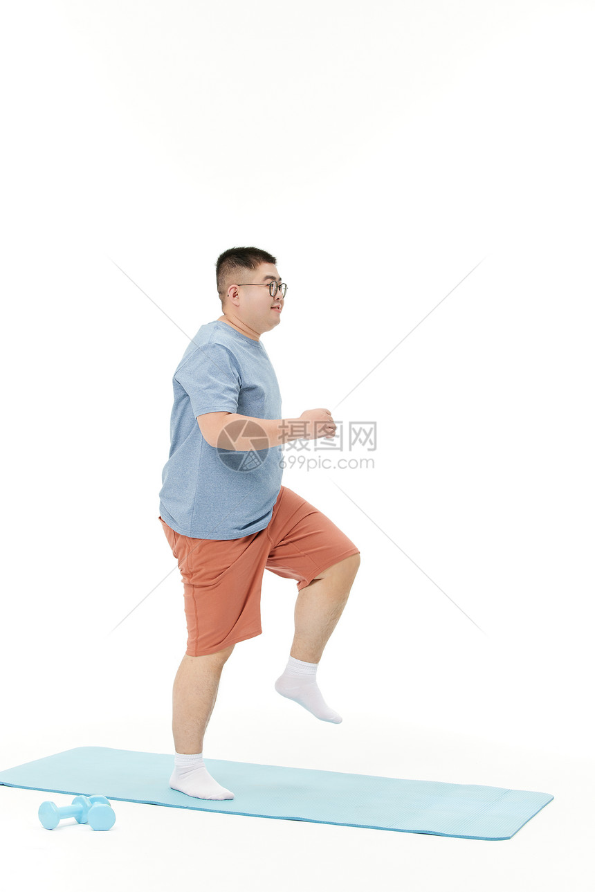 胖子男青年瑜伽垫上锻炼图片