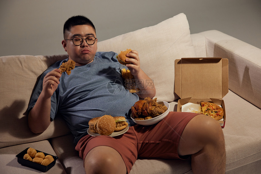 肥胖居家男士夜晚吃美食图片
