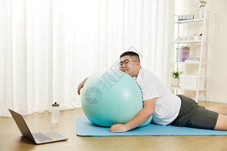 网上视频教程胖子男士趴在瑜伽球上休息背景