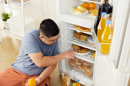 食欲打开肥胖男士冰箱里翻找食物背景