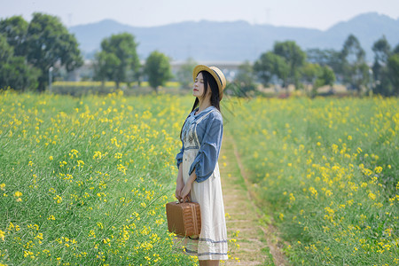 油菜花海里的少女背景图片