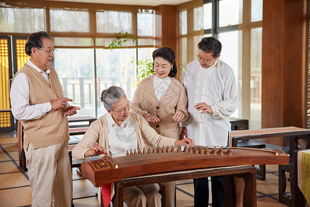 国学教学弹奏古筝的老年人背景