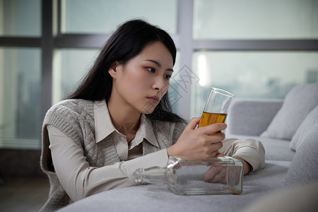 悲伤难过独自喝酒的青年女性高清图片