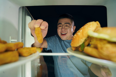 肥胖男青年冰箱挑选美食高清图片