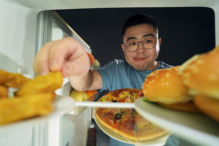 汉堡披萨肥胖男青年在冰箱挑选美食背景