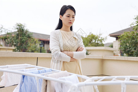 做家务劳累晾晒衣服不开心的女性背景