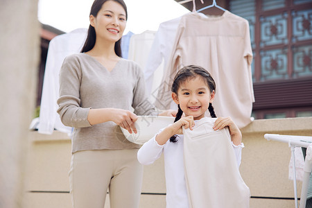 收拾家务妈妈女儿帮妈妈晾晒衣服背景