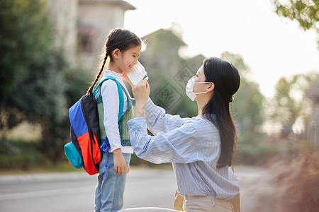 上班妈妈妈妈给上学的女儿戴口罩背景