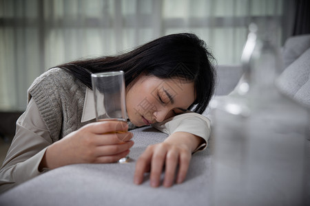 断片悲伤难过喝酒的青年女性醉倒在家背景