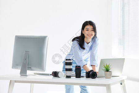 电脑前工作的青年女摄影师图片