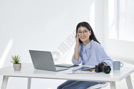 电脑前工作的青年女摄影师背景图片