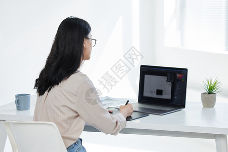 电脑背影女摄影师使用数位板修图背影背景