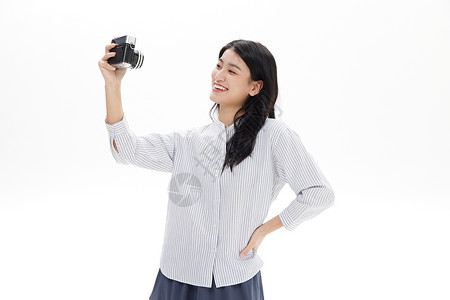 用复古相机拍照的青年女性图片