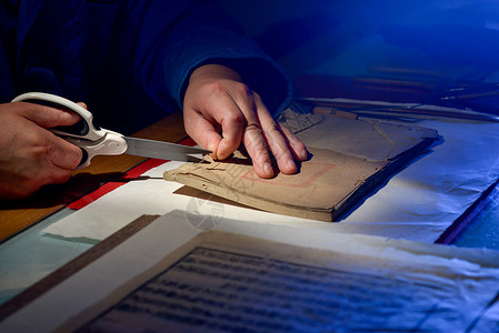 古籍图书馆工作人员在小心的修复古籍背景