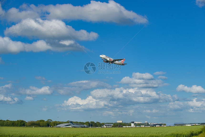 蓝天白云下起飞的民航客机图片