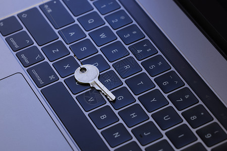 防止电信诈骗被鱼钩挂住的钥匙在键盘前背景