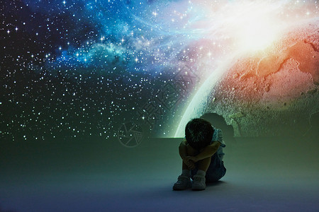 宇宙星河投影前抱腿而坐的小男孩图片
