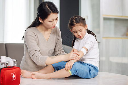 生活常识母亲给受伤的女儿包扎伤口背景