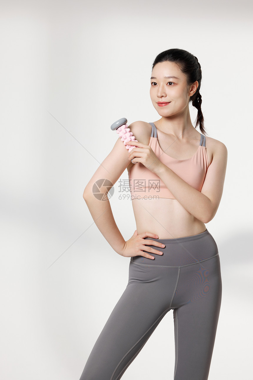 健身后使用器材放松肌肉的女性图片